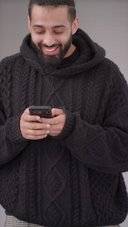 vertical video of excited young man with mobile phone celebrating winning money