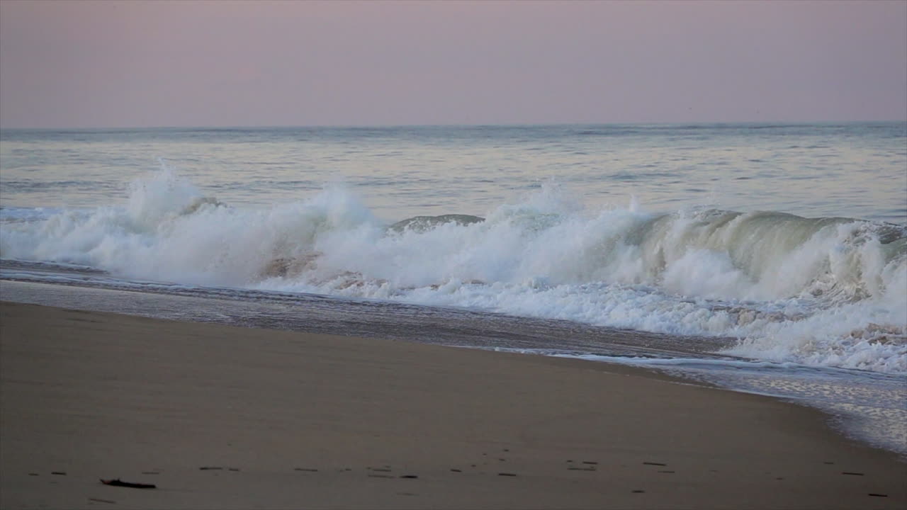Waves break onto shore in early evening