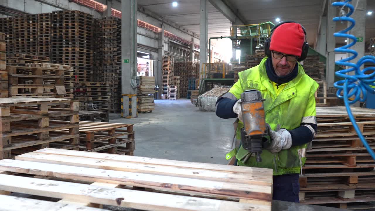 Worker Assembling Pallets in a Warehouse