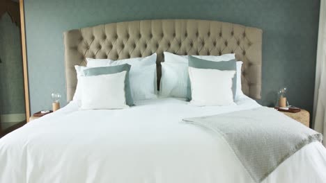 general view of bed with white sheets in bedroom, slow motion