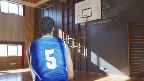 african american male basketball player practicing shooting with ball