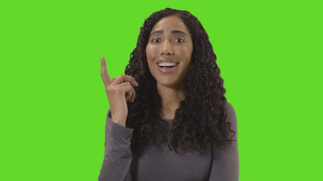 Portrait Of Woman Being Inspired By Good Idea Against Green Screen At Camera