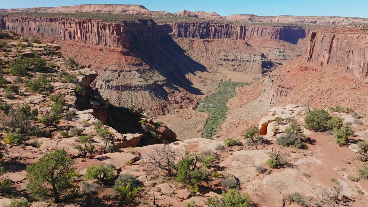 Aerial view of highline athlete over sunny Moab canyon, daring and adrenaline