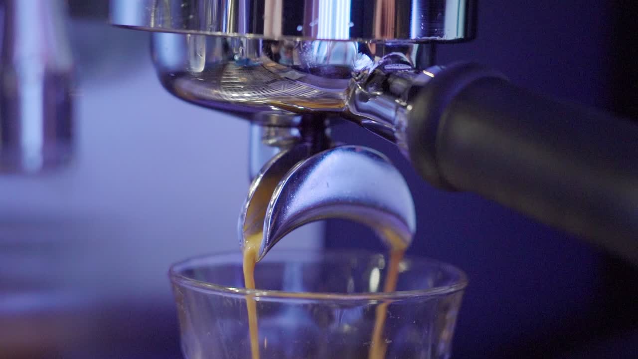 Espresso pouring into a glass from a coffee machine
