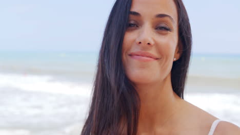 Hermosa-Joven-En-La-Playa-Sonriendo-A-La-Cámara