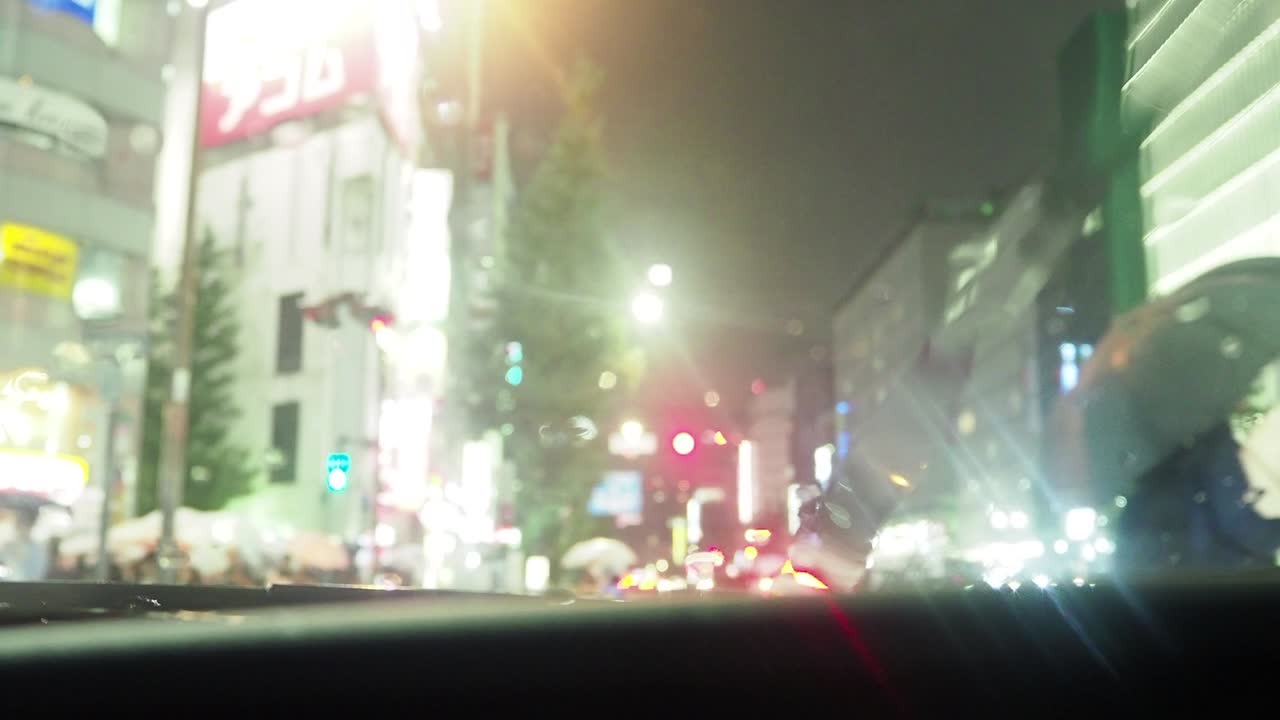 비가 내리는 도쿄 신주쿠의 교차로를 건너는 사람들