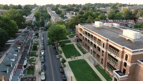 establishing shot of public elementary school building exterior, aerial shot, poor inner city in usa, american youth at risk