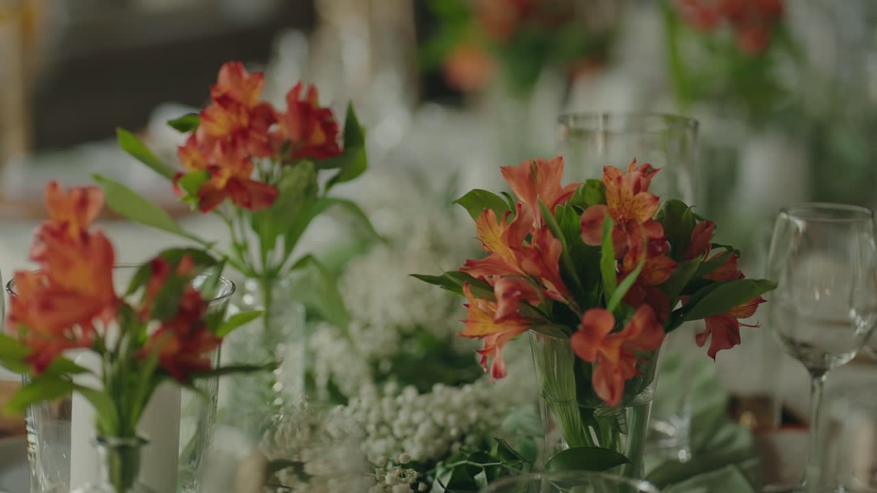 close up of orange floral decorations on elegant wedding dining table
