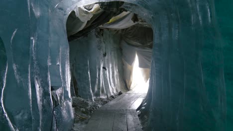 walking inside an ice cave on rhone glacier, in switzerland