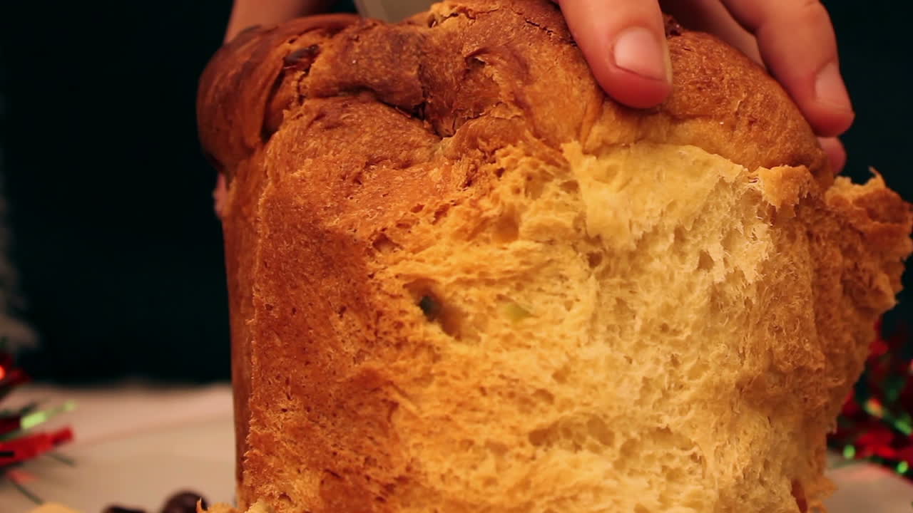Close-up of Hand Slicing a Traditional Panettone Sweet Bread