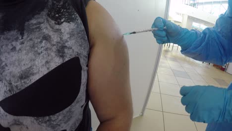 varón adulto siendo vacunado en el brazo contra covid19