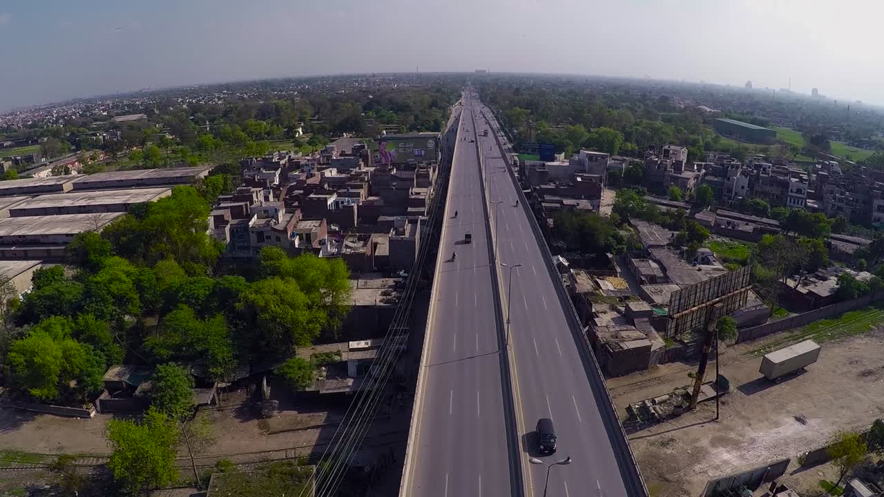antena sobre el puente en la ciudad urbana, india, árboles verdes en la ciudad y techos de casas