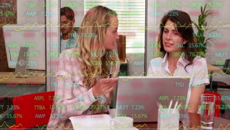 Animation-of-stock-market-data-processing-over-two-caucasian-women-discussing-at-office