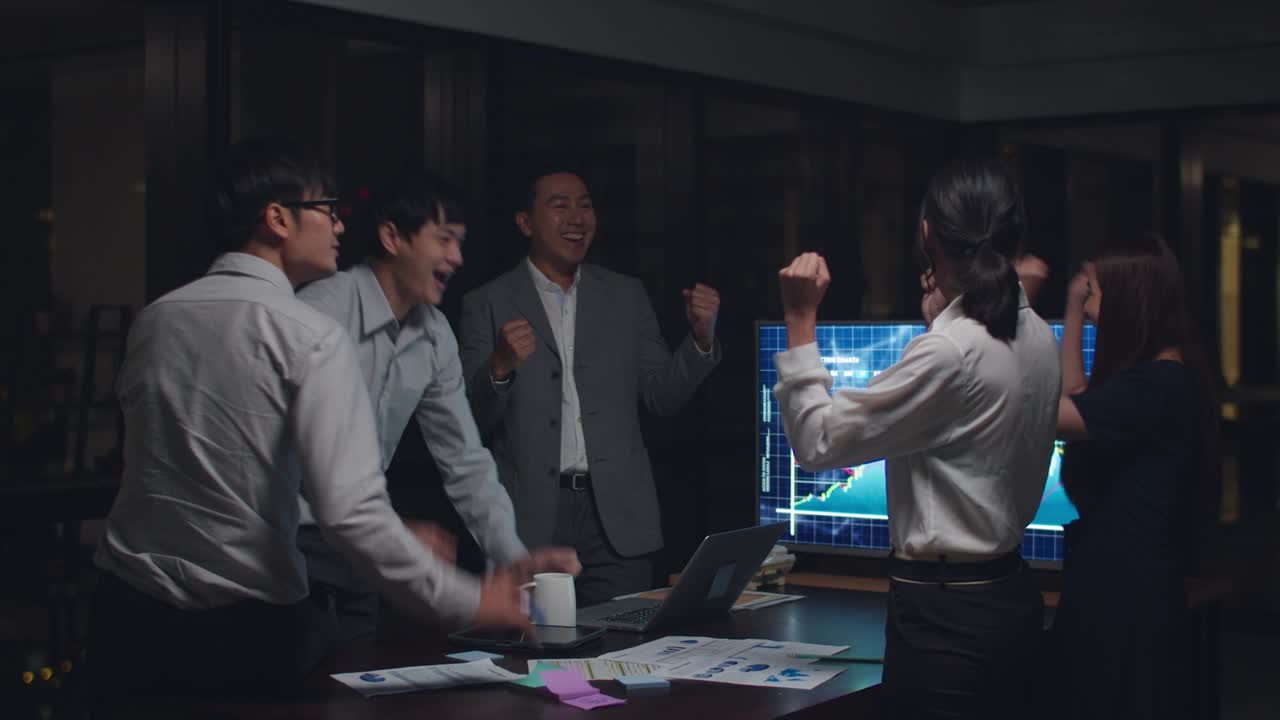 아시아의 사업가들은 밤 사무실의 회의실에서 거래와 계약 또는 협약에 서명 한 후 다섯 가지를 축하합니다.