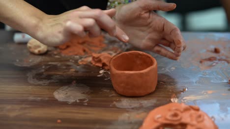 hands shaping clay pot