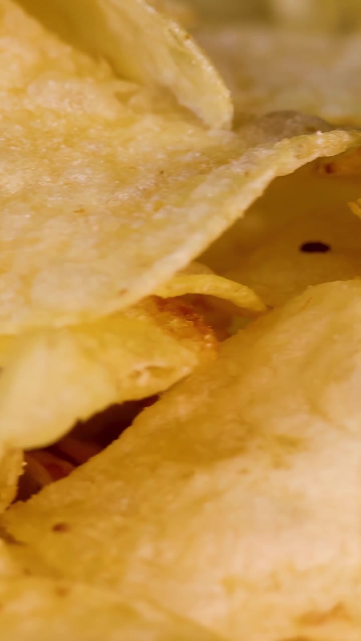 Crispy potato chips rotate under bright studio lighting, highlighting texture and golden color details