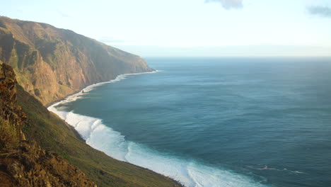 coastline of madeira beautiful, powerful ocean waves crashing against rocky cliffs, creating white foam against the deep blue sea, aerial view rugged coastline and the raw, untamed beauty of nature