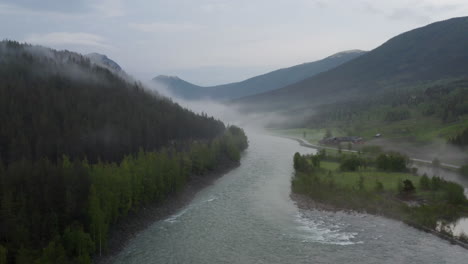 flight over a foggy river. the mist is hanging low over the landscape creating a dark mystical mood over the whole scene