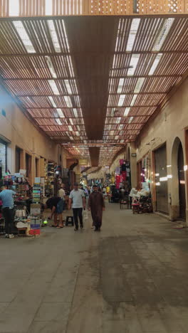 vertical - souk bazaars along ancient medina of marrakesh in morocco. tilt-down reveal
