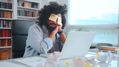 young african american man freelancer sits and sleeping with stickers closed
