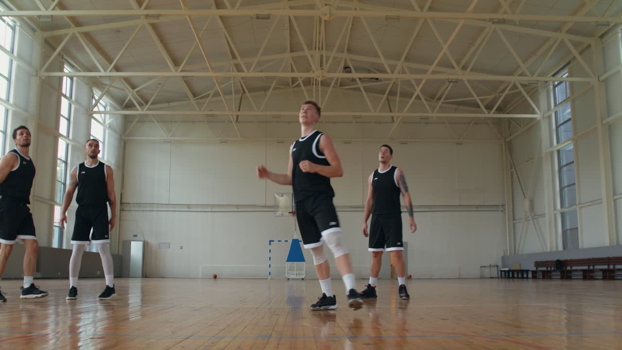 Giocatori di basket che si allenano in un campo al coperto
