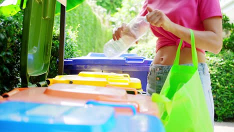 mujer reciclando botella de plástico
