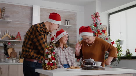 los abuelos celebran la navidad con el nieto trayendo un regalo sorpresa de envoltura de navidad