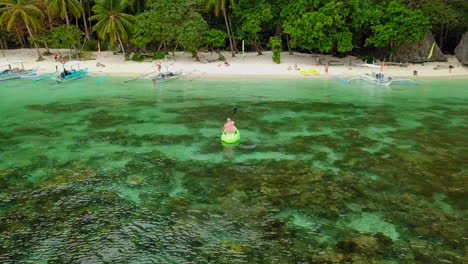 Man-on-Canoe-heading-to-the-beach-in-Palawan,-Philippines