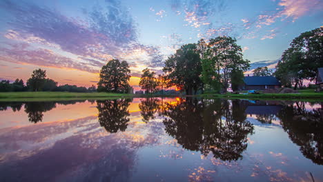 majestic golden hour sunset timelapse of over calm reflective lake with cloudscape skies