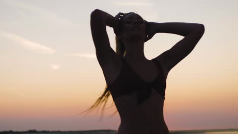 Silueta-De-Una-Chica-Caminando-En-Una-Playa-Durante-Una-Hermosa-Puesta-De-Sol