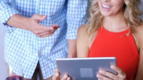 smiling cute couple using digital tablet in front