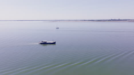 a luxemotor boat cutting through calm, reflective waters in the dutch province of flevoland