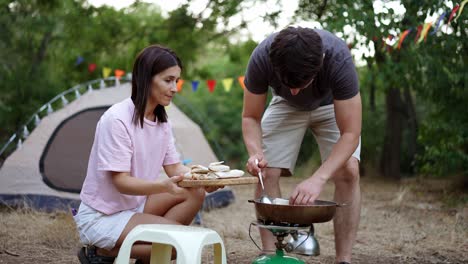 pareja acampando y cocinando