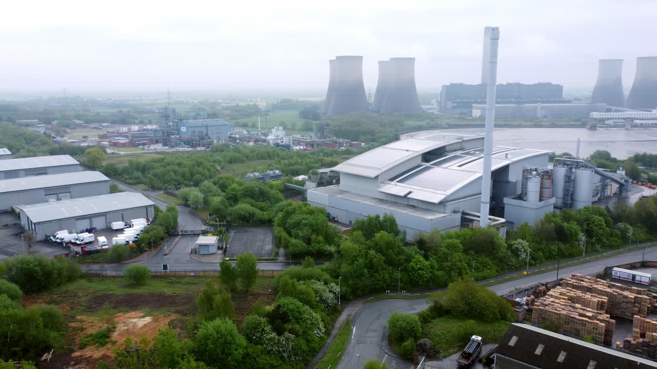 Industrial power station warehouse complex site with green space ecological park land aerial view panning left