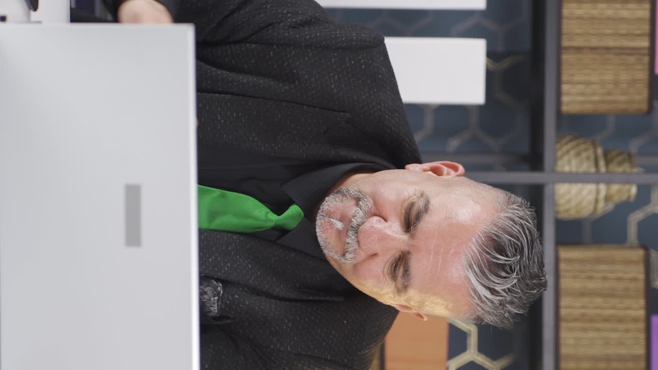 노트북에서 일하는 사업가의 수직 비디오 불행하고 부정적입니다.