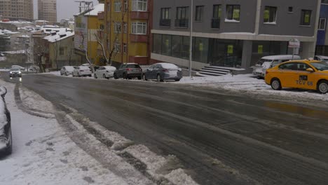 snowy city street with cars and taxi