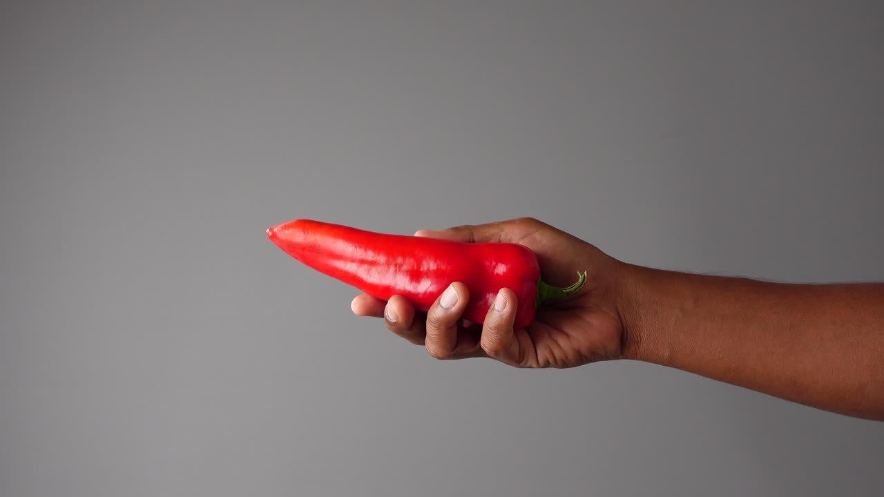 Hand holding a red pepper
