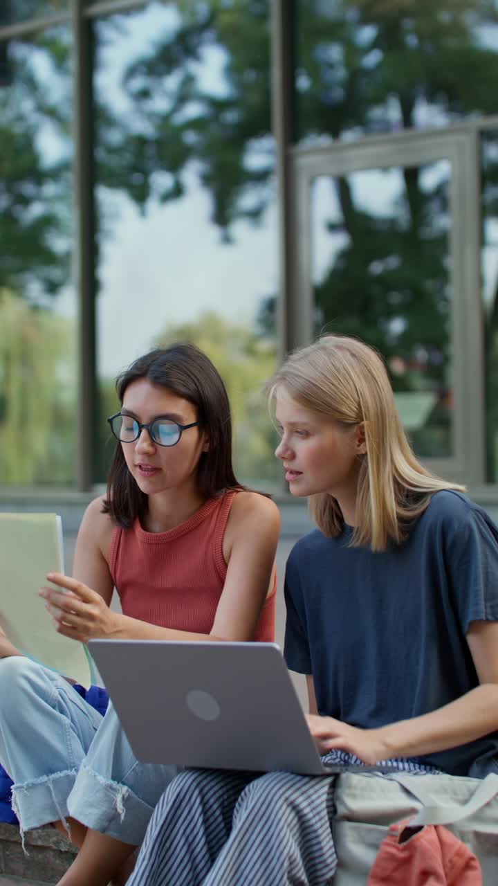 Two female students studying outdoors