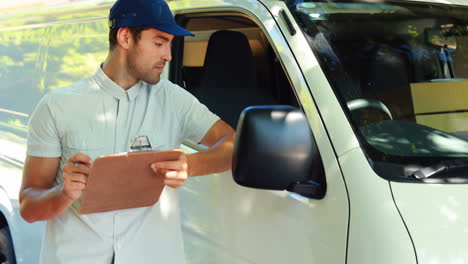 Delivery-man-writing-on-clipboard