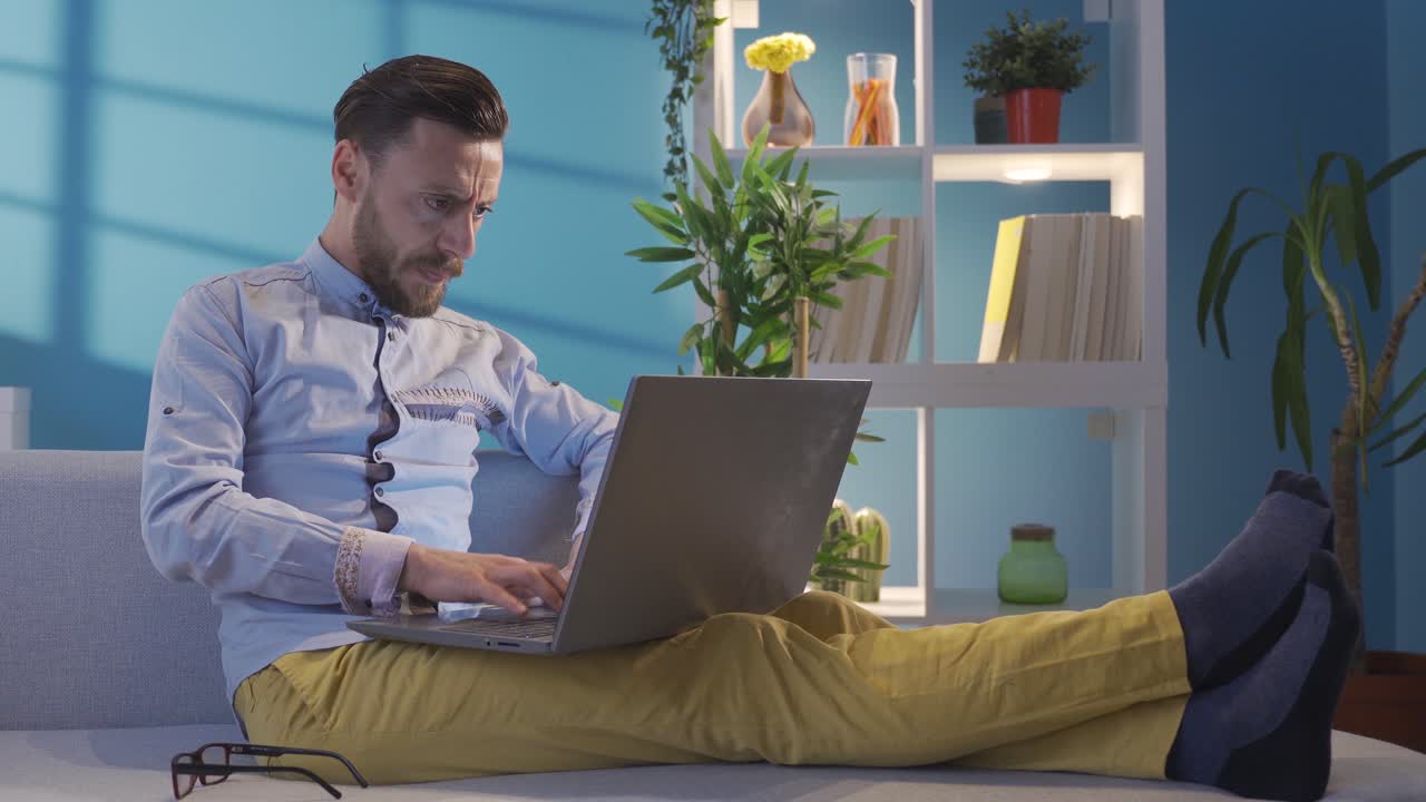 hombre conmocionado trabajando desde la computadora portátil en casa frustrado. hombre elegante y elegante se enoja.