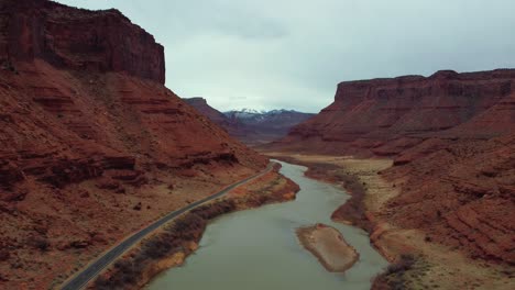 aerial view of asphalt road long the river and canyon in moab, utah