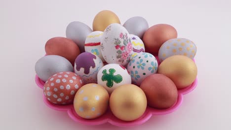 colorful decorated easter eggs on a pink plate