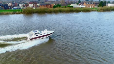 side view of a speedboat as it cruises down the river and creates huge waves