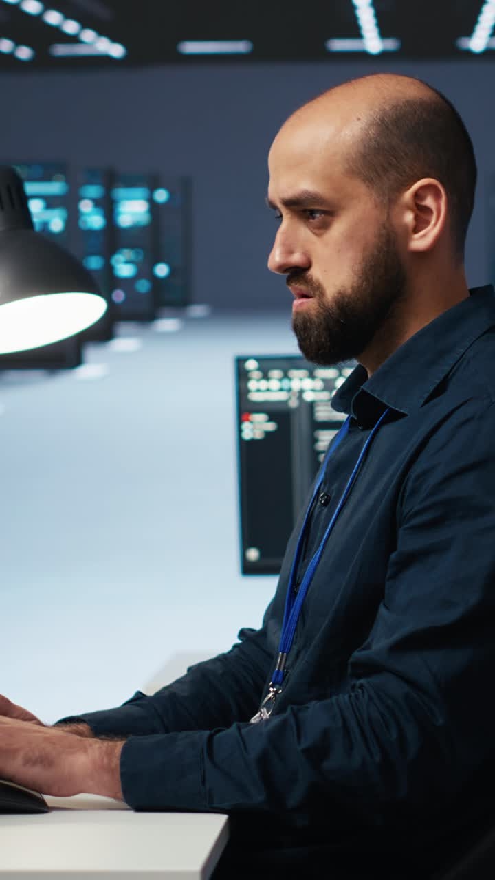 Man Typing Code on Computer in Data Center