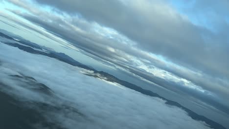 Misty-landscape-shot-from-an-airplane-cabin-near-Pamplona,-Spain,-in-a-left-turn,-just-after-sunrise