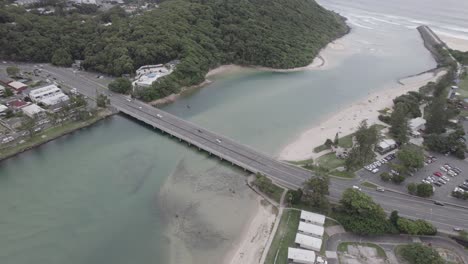 vehicles driving on the bridge over tallebudgera creek in australia. - aerial shot