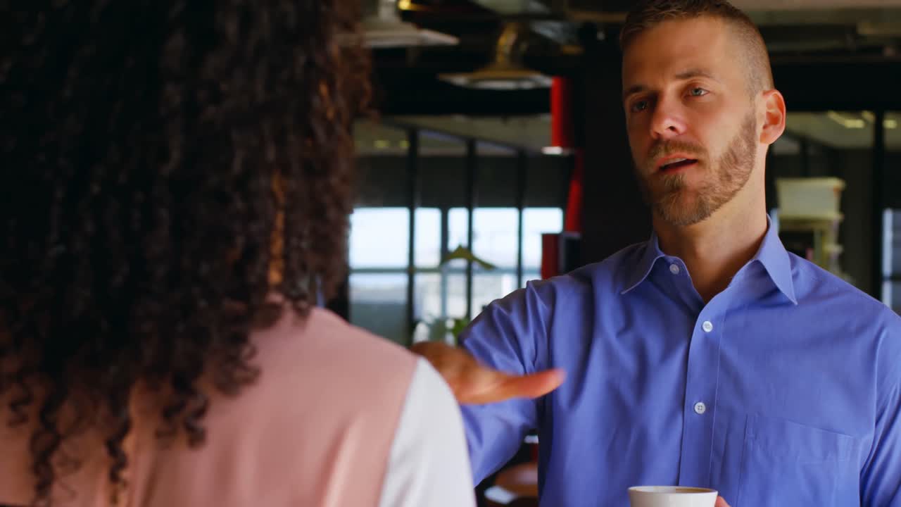 Business colleagues interacting with each other in cafeteria 4k