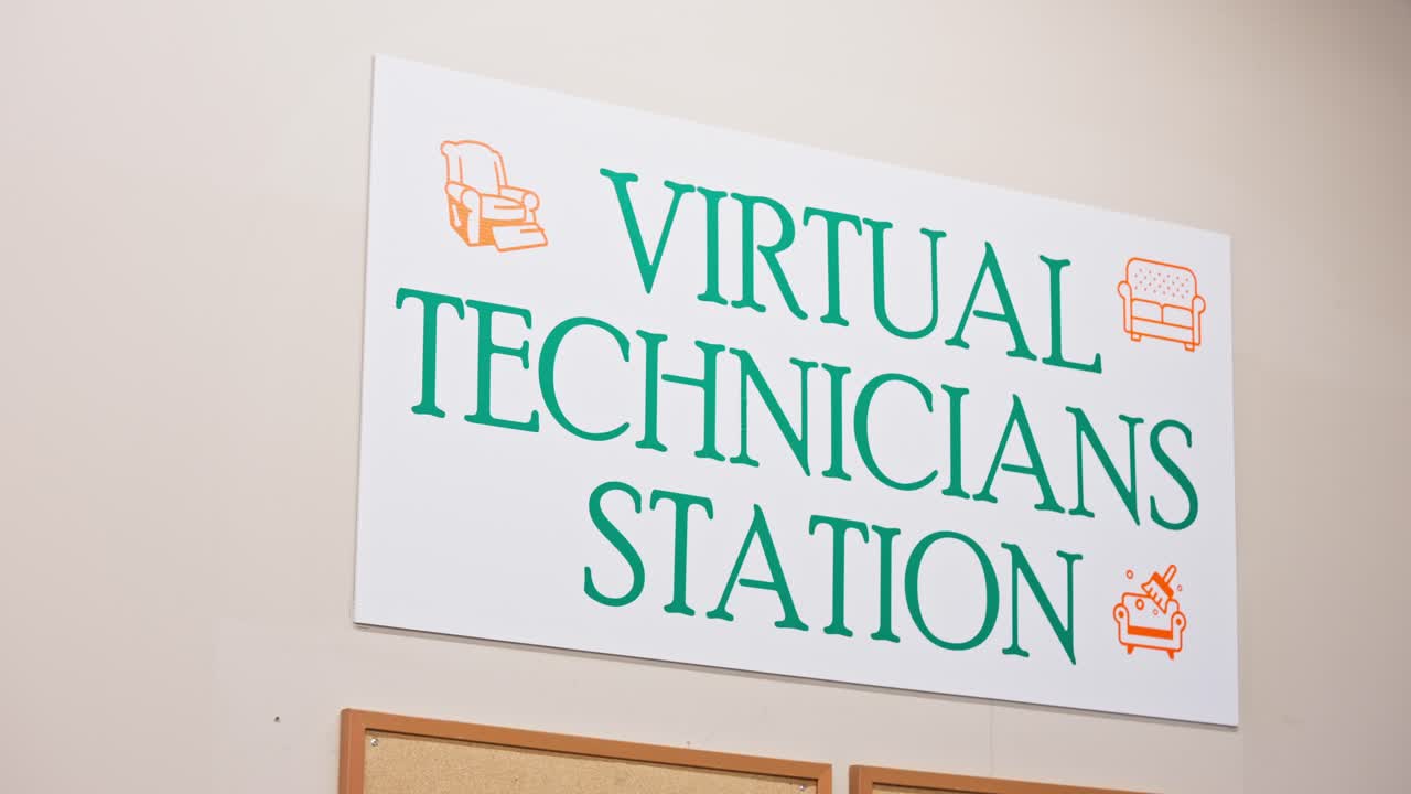 Camera pans slowly across Virtual Technicians Station sign in industrial workshop