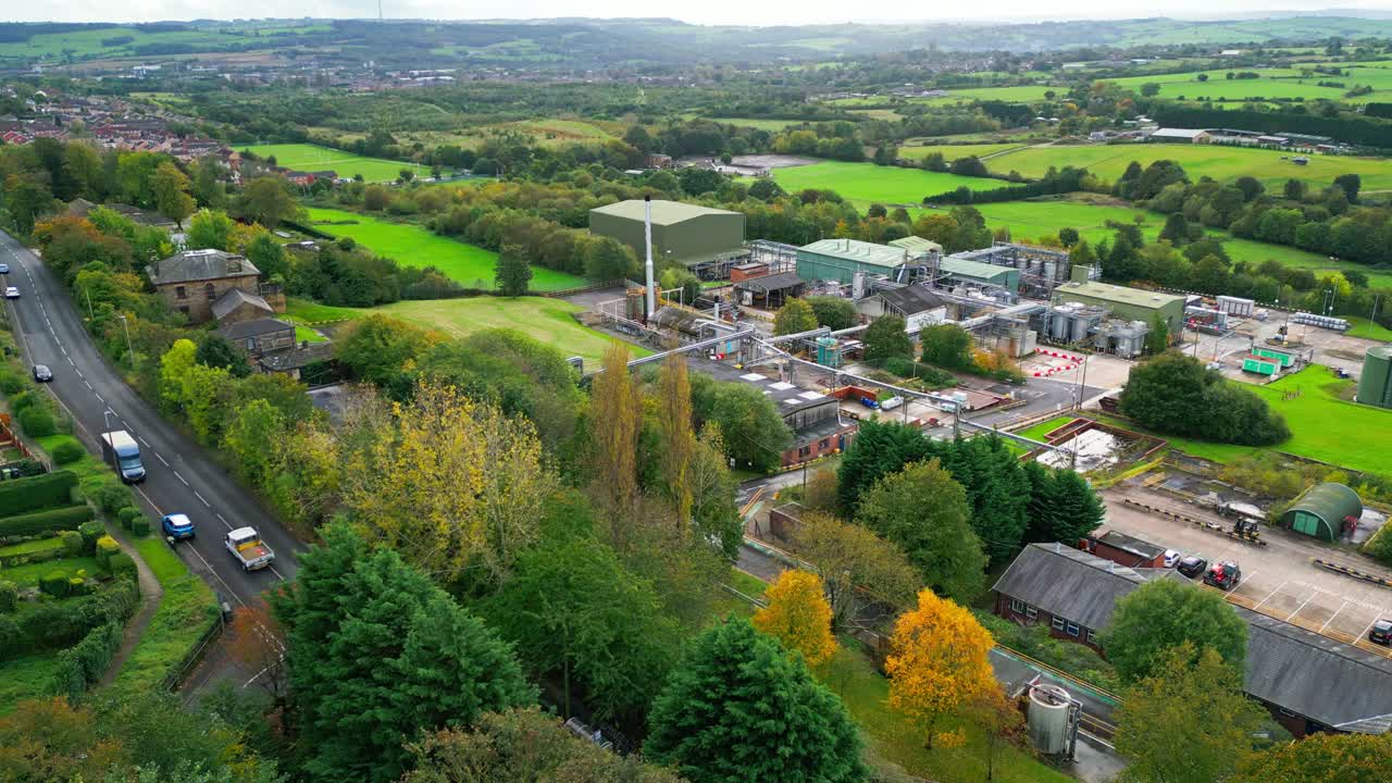 el video aéreo se acerca a una fábrica química del reino unido, destacando tuberías, construcciones metálicas, torres de refrigeración y almacenamiento de químicos