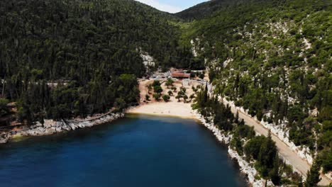 restaurant located in the mountain side overlooking foki beach in italy - aerial shot